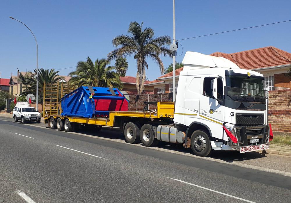 Benecke Transport truck with a lowbed carrying an abnormal load, escort vehicle behind